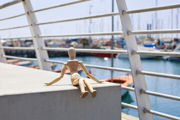Wooden mannequin on block at pier, closeup
