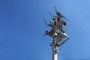 Equipment with electric wires on poles. Recloser is a circuit breaker-like device located in a...