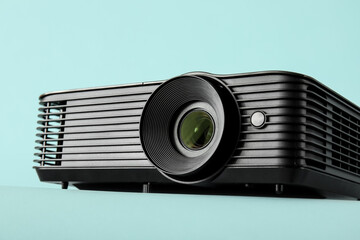 Black video projector on blue background, closeup