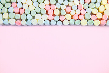 Kolorowe pianki marshmallow na różowym tle
