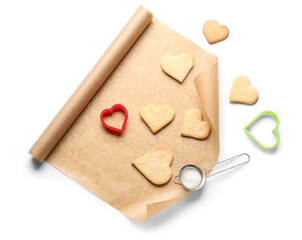 Roll of baking paper, cookies and cutters on white background