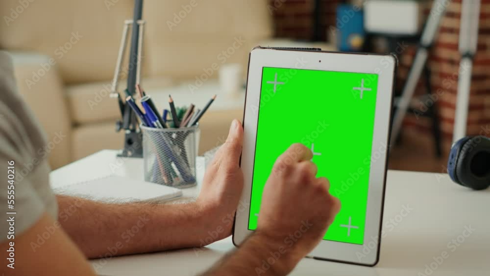 Poster office worker vertically holding digital device with isolated greenscreen, looking at chroma key dis