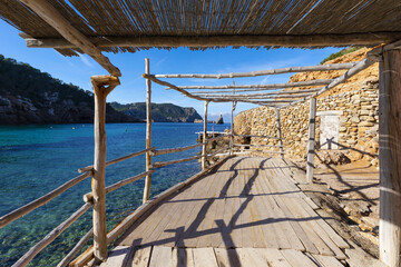 Fototapeta premium Ibiza (Eivissa). Cala Benirrás, vista del islote de Cala Benirrás desde una barraca de pescadores junto a la playa. Islas Baleares, España.