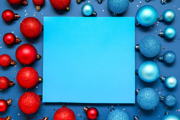 Composition with blank card and beautiful Christmas balls on blue background