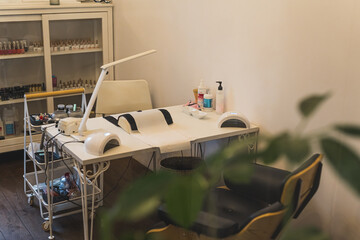 Modern table with nails color palette and lamp situating in the salon, salon interior. High quality...