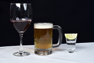 glass of wine, mug of draft beer and shot of Brazilian cachaça pinga