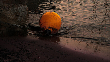 sunset in Queensferry fishing harbor: Orange beach buoy