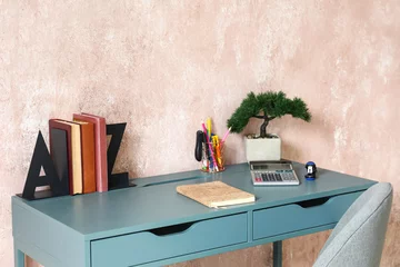 Fotobehang Workplace with bookend and bonsai near pink wall © Pixel-Shot