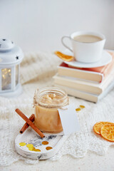 Christmas food. Homemade hazelnut salted caramel spread in glass jar with mockup label at cozy home