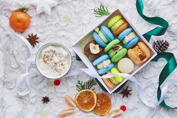 Fototapeta na wymiar Aesthetic box of colorful sweet macaroons, gift for Christmas among winter decorations and marshmallow cocoa