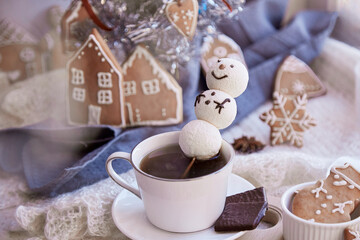 Obraz na płótnie Canvas Winter aesthetic morning. Marshmallow snowman in hot chocolate, ginger cookies near Christmas tree. Cozy warm home