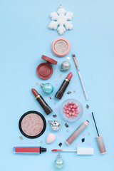 Christmas tree made of cosmetics and decorations on color background