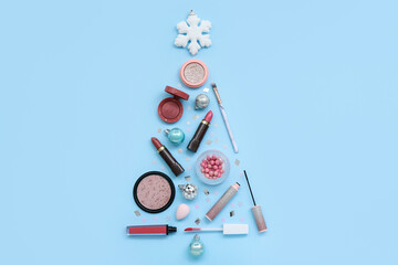 Christmas tree made of cosmetics and decorations on color background