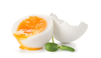 Sliced soft boiled egg, shell and micro green on white background