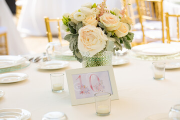 Wedding reception or other outdoor festive event. Luxury wedding reception dining table and gold decoration on a table. Table set for a party event or wedding reception.