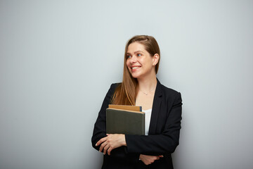 Smiling woman teacher holding book and looking away. Isolated portrait with copy space.