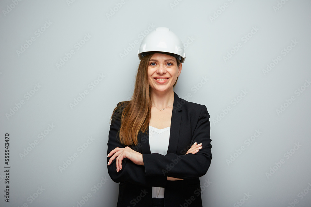 Wall mural smiling woman contractor in white helmet and black suit. isolated female portrait.