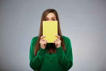 Woman teacher or student covered her face with yellow book. Isolated advertising portrait. - 555543803