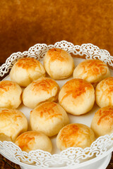 Portion of traditional Brazilian cheese bread on white tray