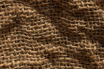 Texture of natural burlap material close-up, with natural folds and draperies