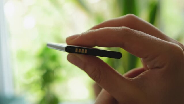 swollen battery. a man holds a swollen battery in his hand