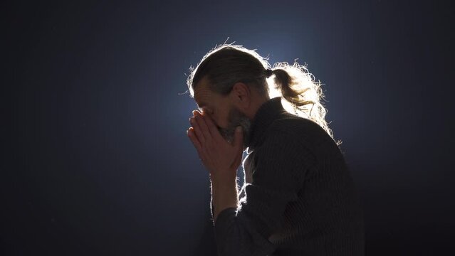 Worried and stressed man talking to himself. On black background.
The man who commits a crime or makes a mistake gets angry with himself and gets stressed.
