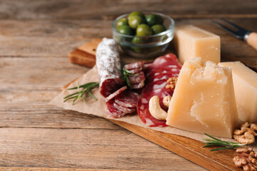 Snack platter with parmesan cheese on wooden table, closeup. Space for text