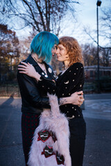 unconventional lesbian couple embrace in urban park at sunset