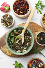 Many different herbal teas on white wooden table, flat lay
