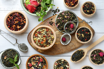 Many different herbal teas on white wooden table, flat lay
