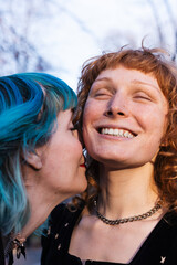 close up of smiling lesbian couple in urban park at sunset