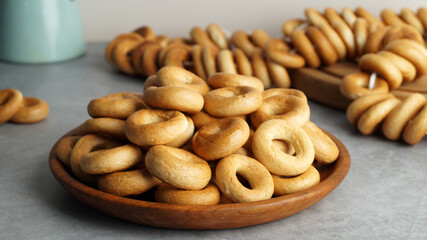 Plate with delicious ring shaped Sushki (dry bagels) on light grey table, closeup