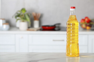 Bottle of cooking oil on white marble table in kitchen. Space for text