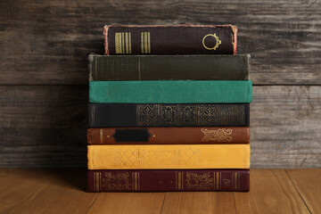 Stack of old hardcover books on wooden table