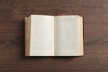 Obraz premium Open old hardcover book on wooden table, top view