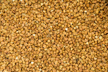 Texture of buckwheat. Detailed photo of spilled buckwheat, raw vegetarian food