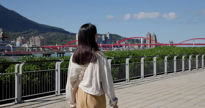 Woman walk beside the tamsui river