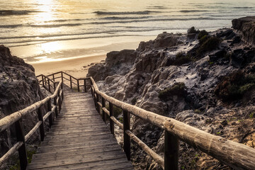 wooden staircase between cliffs leading to the beach