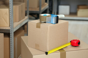 Adhesive tape dispenser on cardboard box indoors