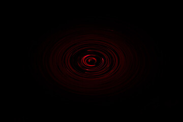 Center red light swirled silhouette on black background. Concept of curve art picture. Dark picture for website, avatar, Surreal Black and red abstract backdrop