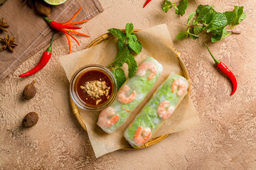 Fototapeta na wymiar Fresh Spring Roll with shrimps, Vietnamese Food top view on brown table