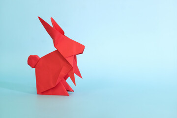 Red rabbit or bunny origami isolated in blue background. Chinese new year of the rabbit and easter...