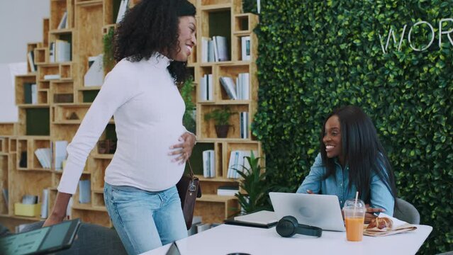 Pregnant, black woman and meeting in office with tablet app design idea on screen and friendly staff at company. Creative, technology and care of coworkers happy for pregnant woman in workplace.