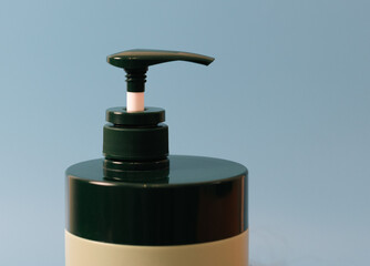 Fototapeta na wymiar Shampoo bottle with dispenser on blue.