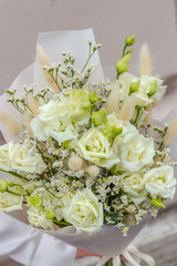 Big white bouquet with lisianthus flowers in woman hands