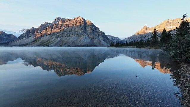 Steam Fog Over Bow Lake With Reflections Of Crowfoot Mountain Within The Banff National Park in Alberta, Canada. - wide
