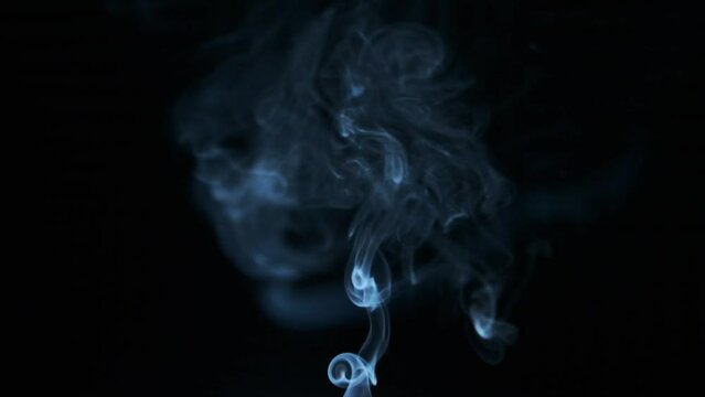 Smoke floating in the air on a black background