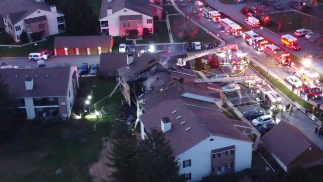 flying over a condominium house fire with firetrucks and ambulances