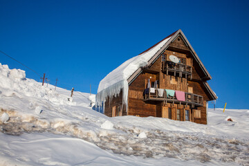 traditional beautiful wooden house - wintry scene with snowy hut on a ski resort