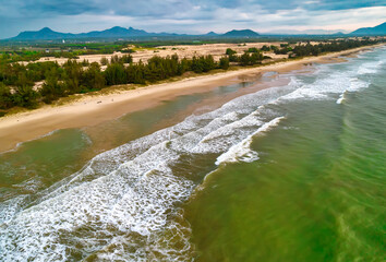 Beach scene with waves crashing on the golden sand are so beautiful from above, the beach is for relaxing and bathing